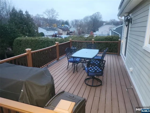 a balcony with wooden floor table and chairs