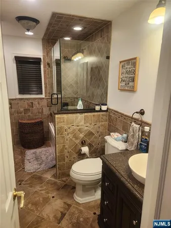 a bathroom with a toilet a sink and mirror