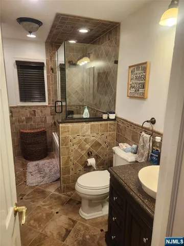 a bathroom with a toilet a sink and mirror