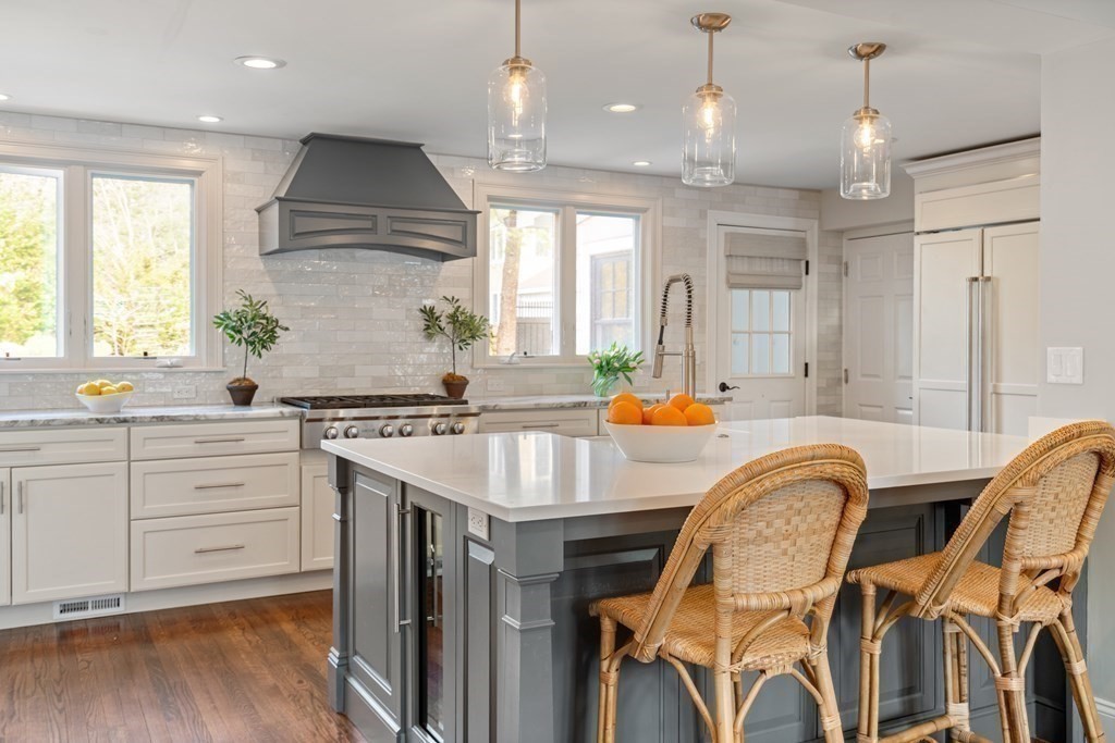15 Old Town Road Wellesley, MA 02481 - Photo 4 of 30 a kitchen with stainless steel appliances granite countertop a kitchen island a stove a sink cabinets and a dining table with wooden floor