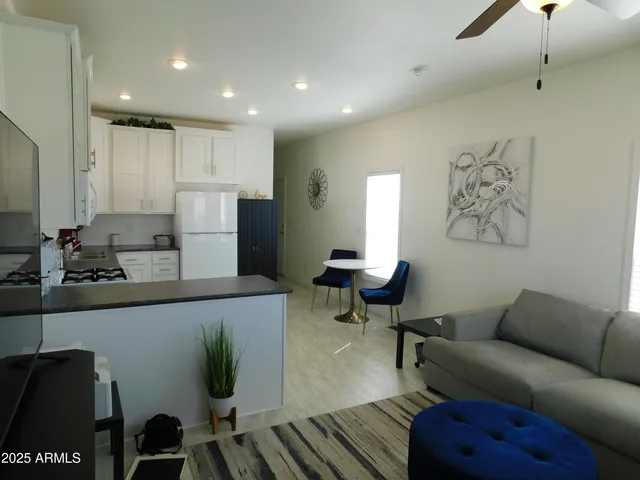 a living room with furniture and a dining table with wooden floor