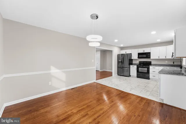 a view of a kitchen with wooden floor and electronic appliances