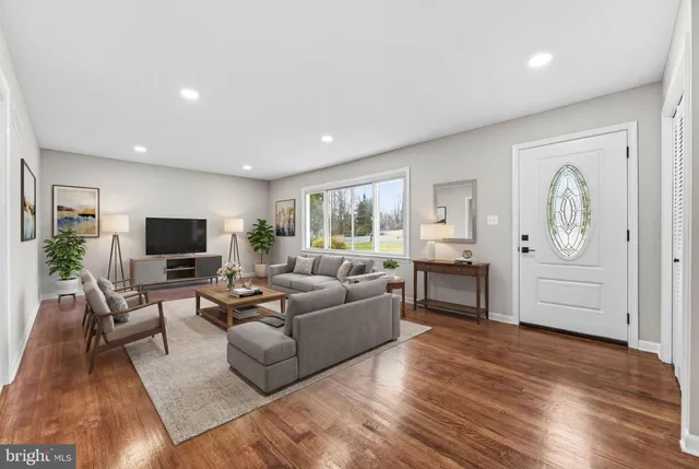 a living room with furniture wooden floor and a flat screen tv