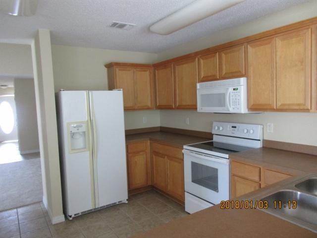 210 South Harborview Road Santa Rosa Beach, FL 32459 - Photo 4 of 12 a kitchen with a refrigerator sink and cabinets