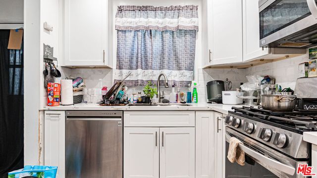 a kitchen with stainless steel appliances granite countertop a refrigerator and a stove