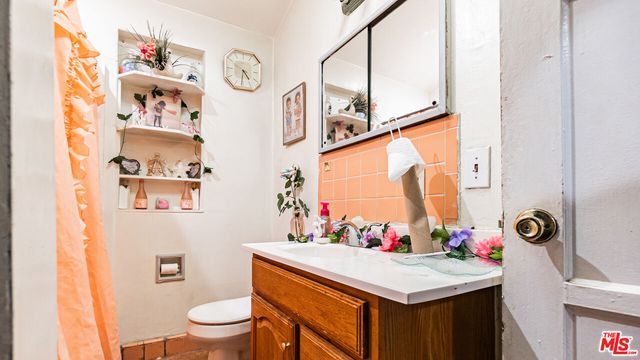 a bathroom with a sink vanity mirror and toilet