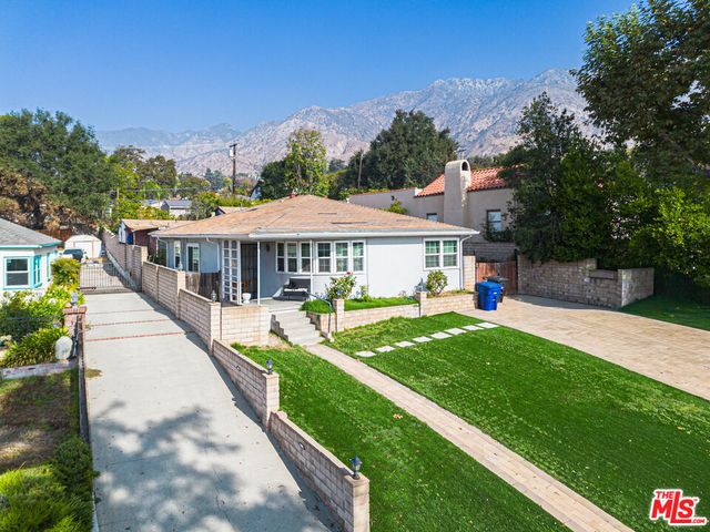 a view of a house with backyard and sitting area