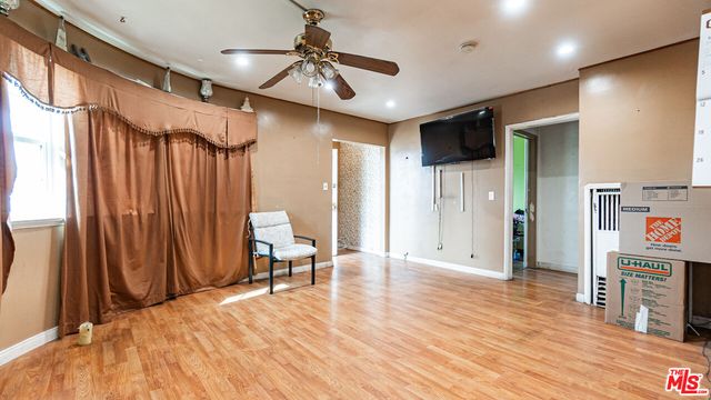 a view of a hallway with wooden floor and furniture