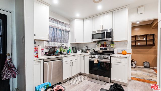 a kitchen with stainless steel appliances a stove a sink and a refrigerator