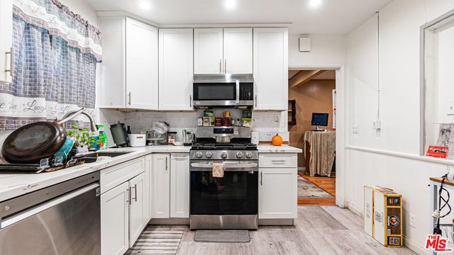 a kitchen with stainless steel appliances a stove a sink a microwave and cabinets