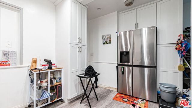 a kitchen with stainless steel appliances a refrigerator and a wooden floor