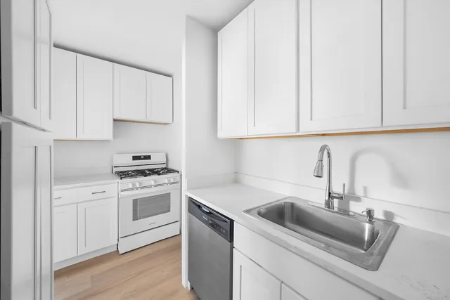 a kitchen with white cabinets and a sink