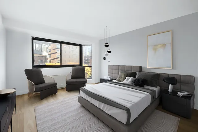 a spacious bedroom with a bed and wooden floor