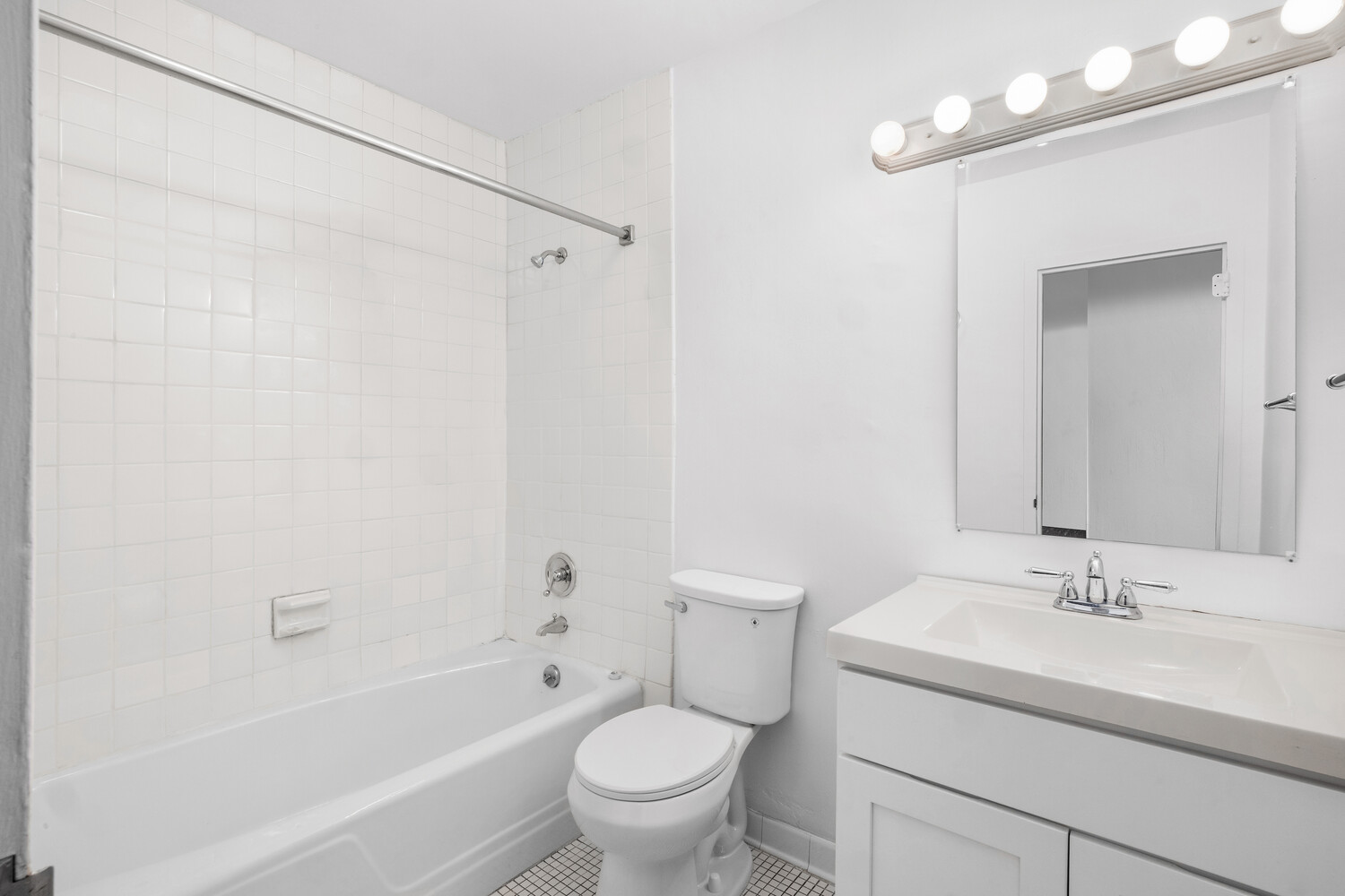 1725 York Avenue, Unit 5E Manhattan, NY 10128 - Photo 9 of 13 a bathroom with a sink toilet a mirror and shower