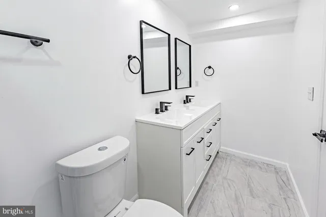 a bathroom with a sink a toilet and a mirror