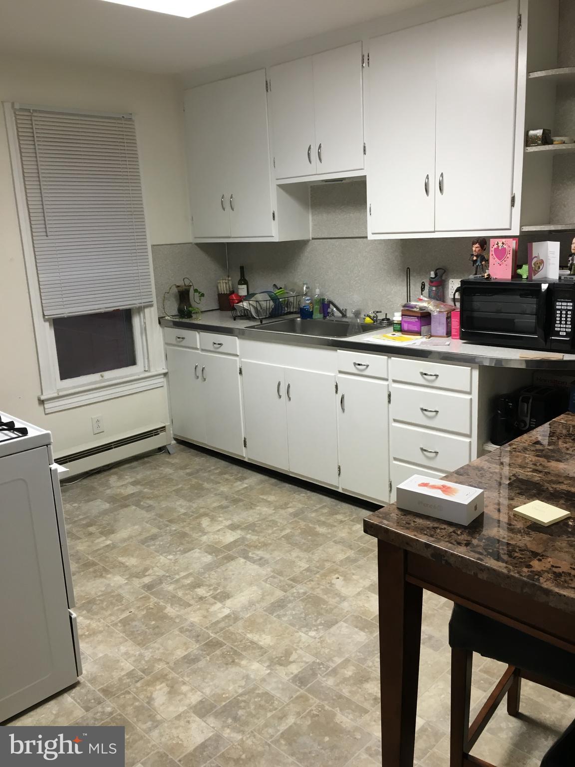 213 Locust Street Hanover, PA 17331 - Photo 2 of 9 a kitchen with granite countertop a stove a sink and a refrigerator