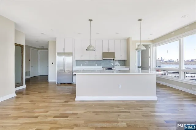 a view living room with stainless steel appliances granite countertop kitchen island sink refrigerator and window