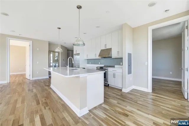 a white kitchen with wooden floor