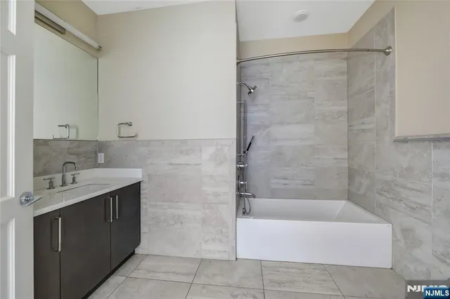 a bathroom with a bathtub sink vanity and mirror