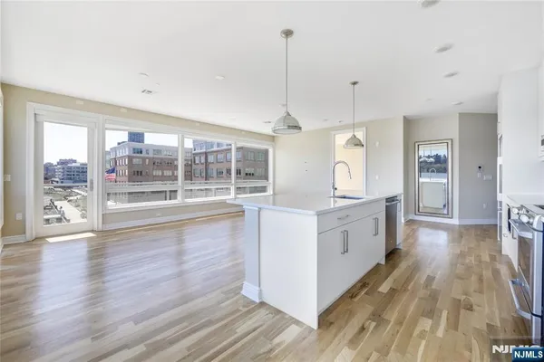 a large kitchen with granite countertop a large counter top a sink appliances and cabinets