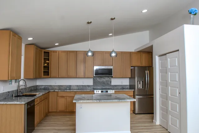 a kitchen with stainless steel appliances granite countertop a sink stove and refrigerator