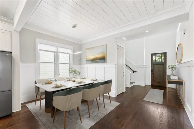 a kitchen with stainless steel appliances granite countertop a refrigerator a sink dishwasher a stove and white cabinets with wooden floor