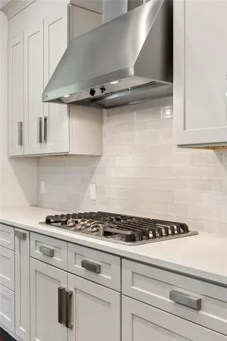 a kitchen with white cabinets and a stove