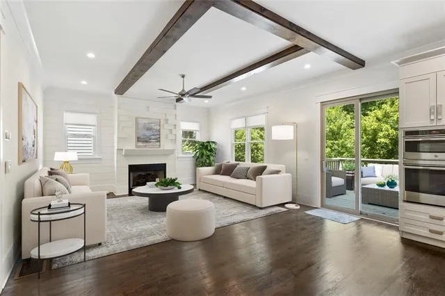 a living room with furniture kitchen view and a large window