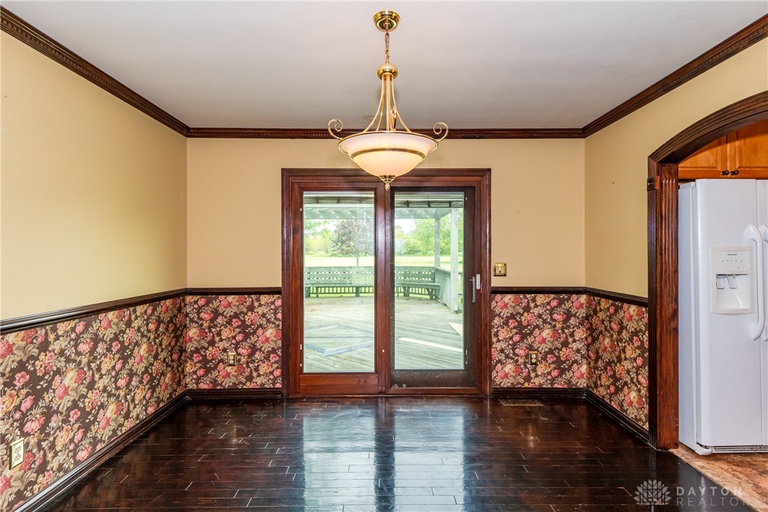 9981 Ridge Acres Lane Englewood, OH 45322 - Photo 17 of 73 This inviting dining area features elegant crown molding and rich hardwood flooring, offering a perfect setting for gatherings.