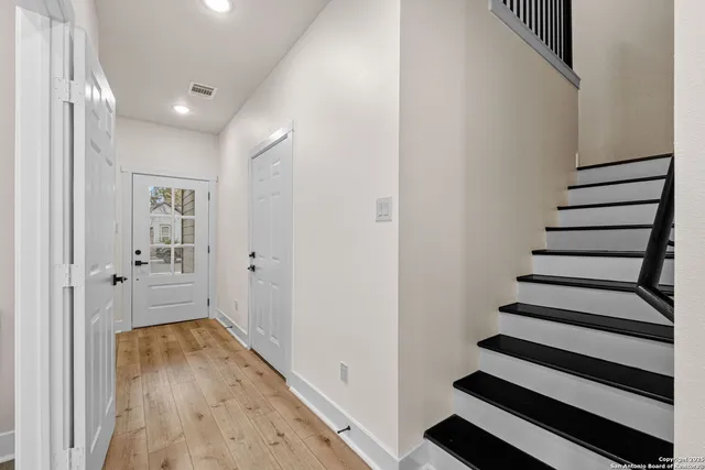 a view of a hallway with wooden floor and windows