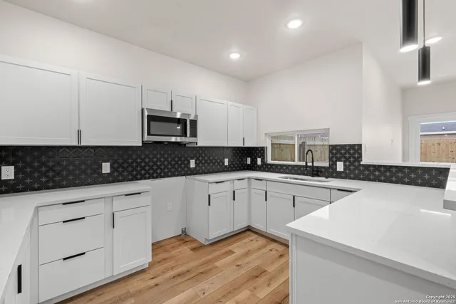 a kitchen with granite countertop white cabinets and stainless steel appliances