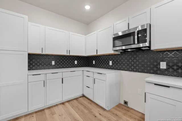 a kitchen with stainless steel appliances granite countertop white cabinets granite counter tops and a stove