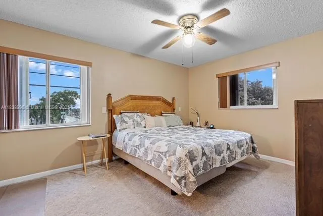 a bedroom with a bed chandelier and a window