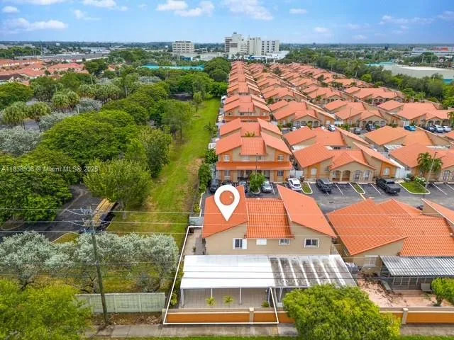 an aerial view of residential houses with outdoor space and trees