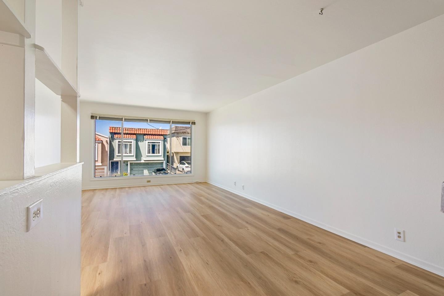 931 Hillside Boulevard Daly City, CA 94014 - Photo 13 of 63 wooden floor in an empty room with a window