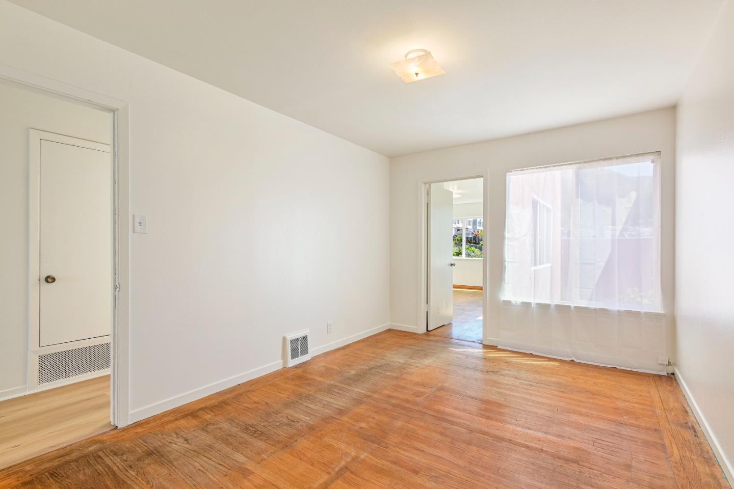 931 Hillside Boulevard Daly City, CA 94014 - Photo 27 of 63 a view of an empty room with window and wooden floor