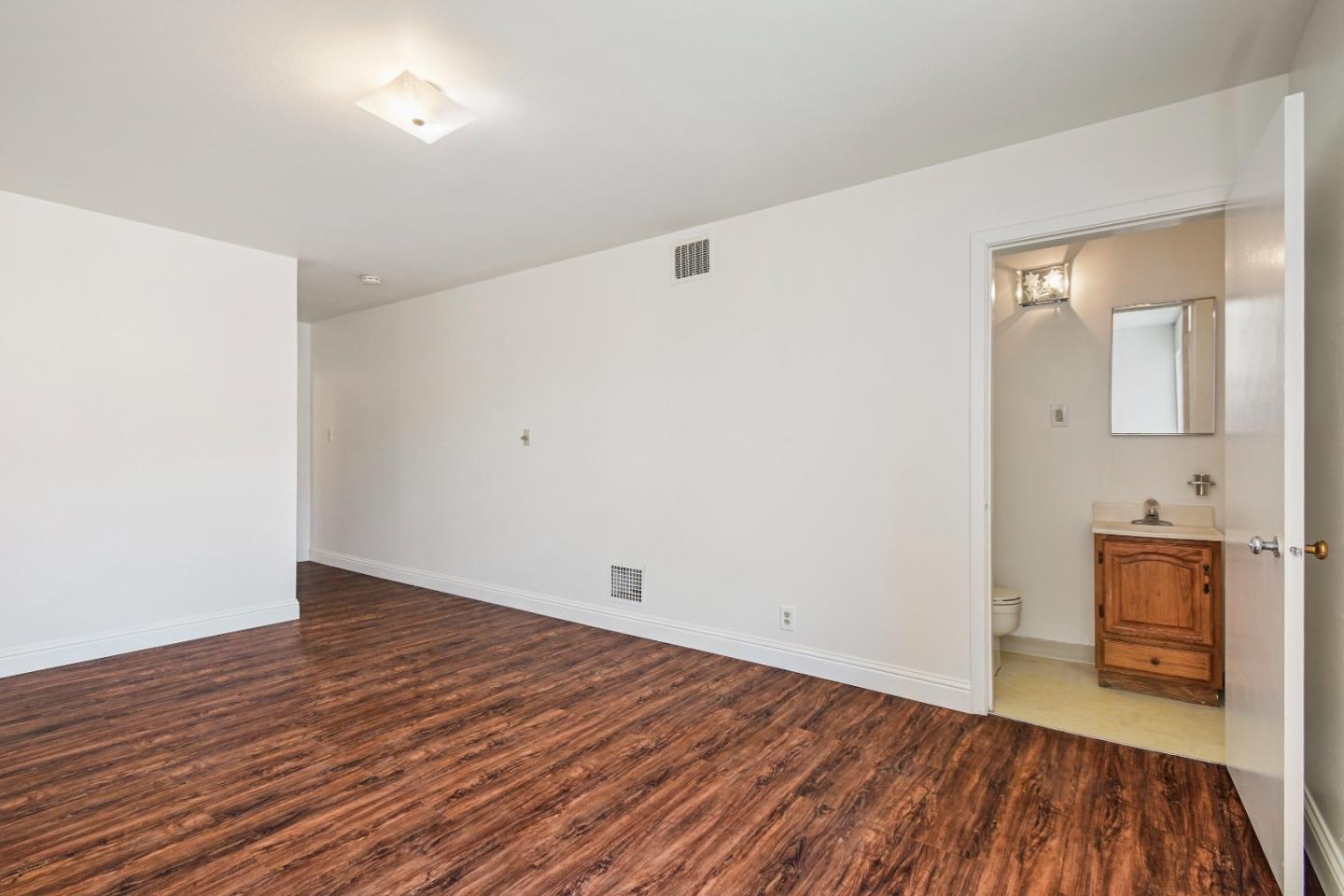 931 Hillside Boulevard Daly City, CA 94014 - Photo 37 of 63 an empty room with wooden floor and windows