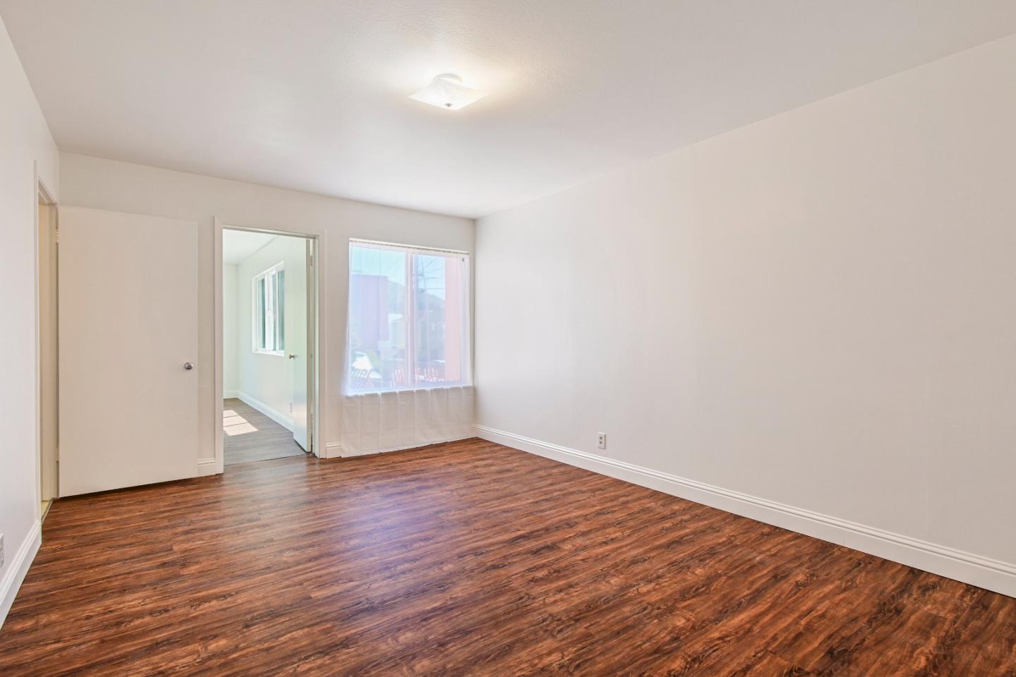 931 Hillside Boulevard Daly City, CA 94014 - Photo 39 of 63 a view of an empty room with wooden floor and window