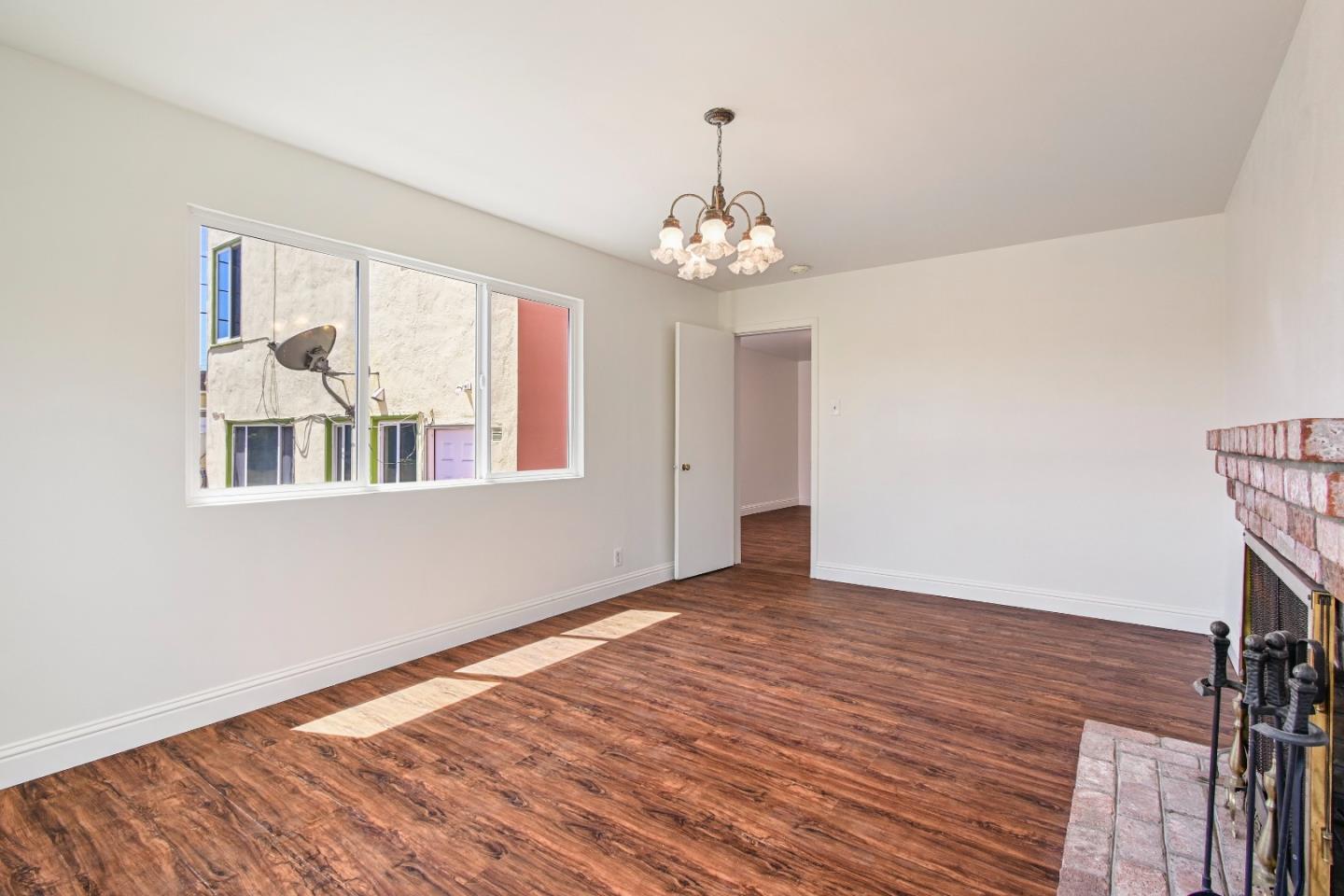 931 Hillside Boulevard Daly City, CA 94014 - Photo 43 of 63 a view of an empty room with wooden floor and a window