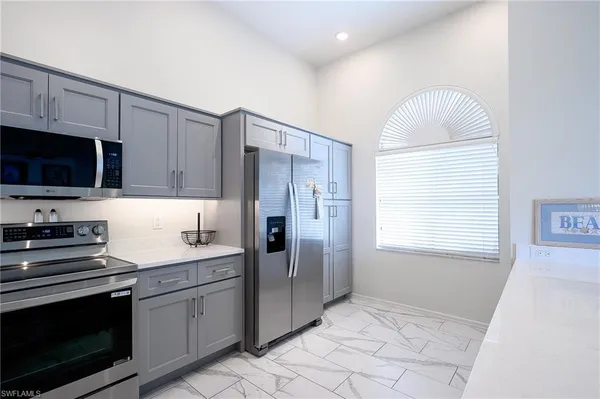 a kitchen with stainless steel appliances granite countertop a stove a sink and a refrigerator