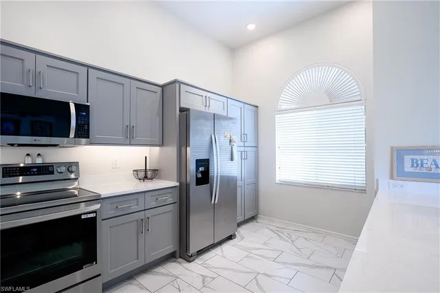a kitchen with stainless steel appliances granite countertop a stove a sink and a refrigerator