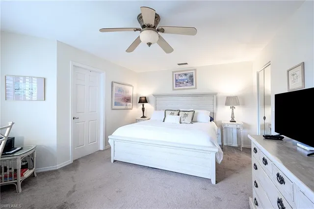 a bedroom with a bed and a flat tv screen on the dresser