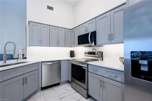 a kitchen with cabinets appliances and a sink