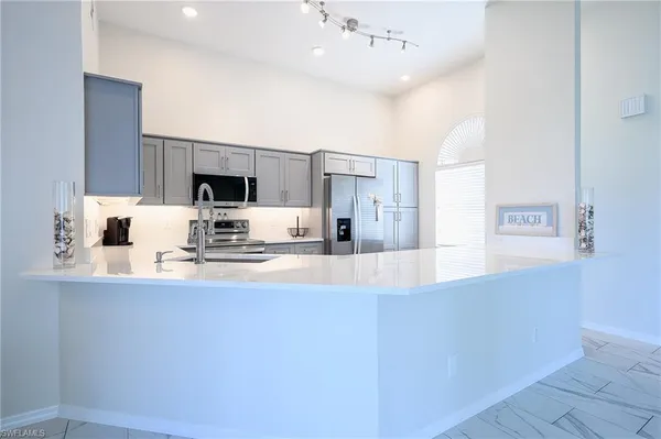 a large kitchen with kitchen island a sink stainless steel appliances and cabinets