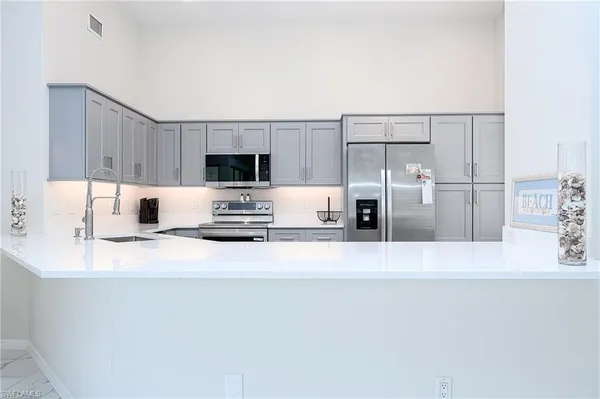 a kitchen with a refrigerator and a stove top oven