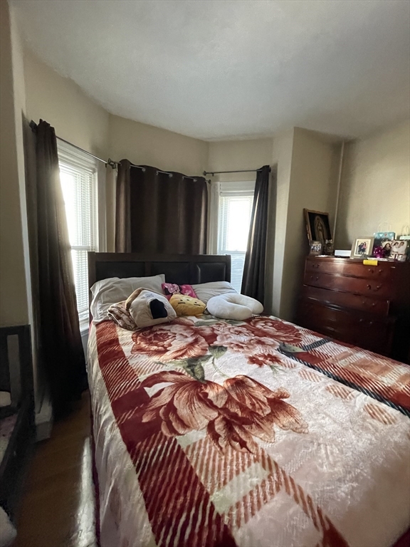 109 Wordsworth Street, Unit 2 Boston, MA 02128 - Photo 12 of 16 a bedroom with a bed and dresser with mirror