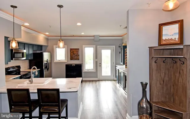 a kitchen with stainless steel appliances a dining table chairs stove and refrigerator