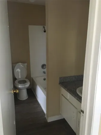 a bathroom with a granite countertop toilet and sink