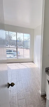 a view of an empty room with a fireplace and a window