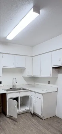 a kitchen with granite countertop white cabinets and white appliances